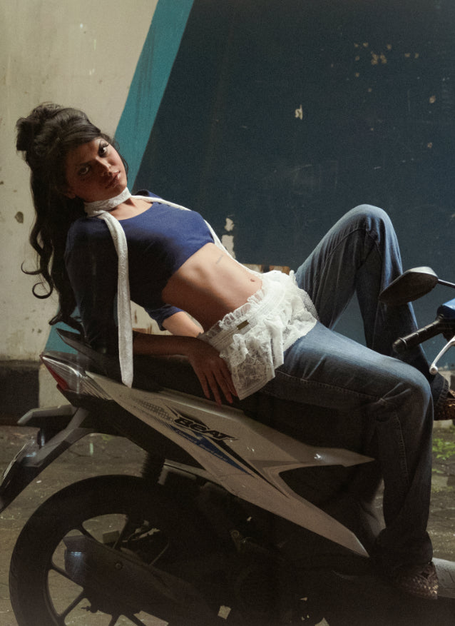 Woman sitting on a motorcycle with a white lace skirt