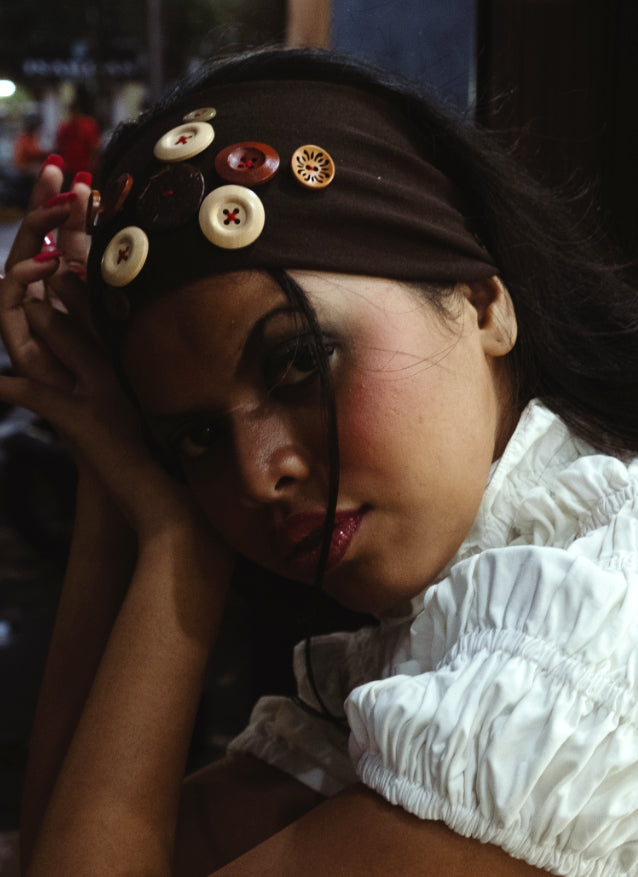 Woman wearing a headband with buttons in an urban setting