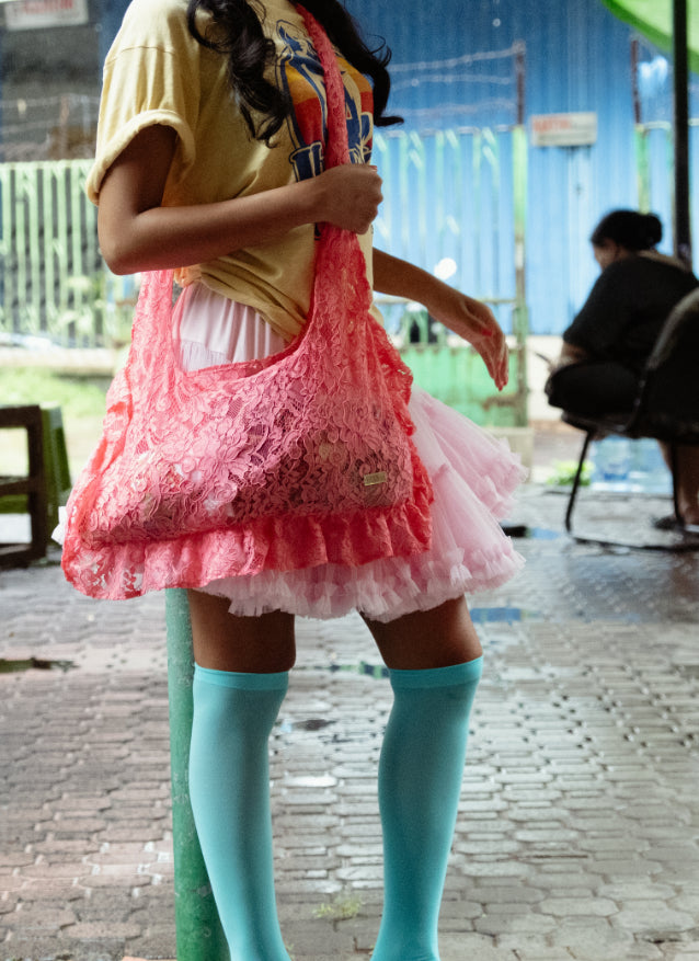 Person wearing a pink lace bag and colorful outfit 